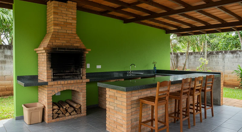 design de área gourmet com fogão a lenha e churrasqueira