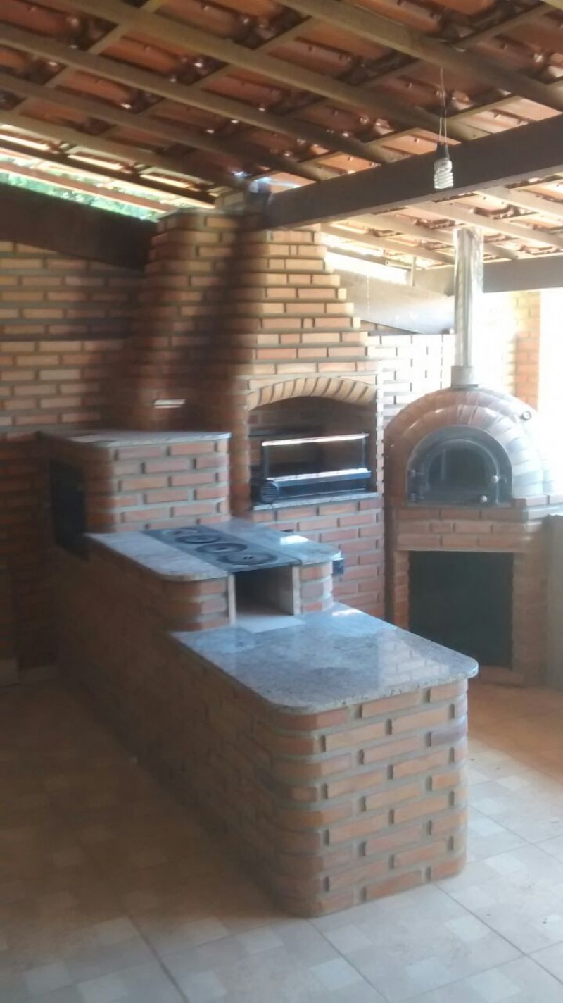 área gourmet com churrasqueira e fogão a lenha integrado