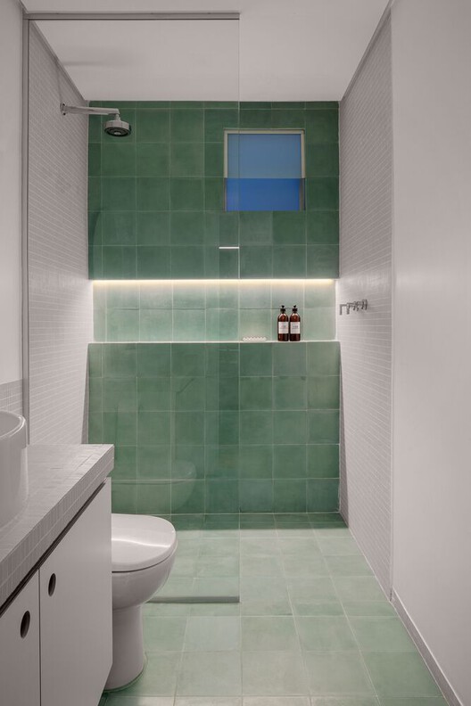 banheiro bicolor com cerâmica branca e verde escuro