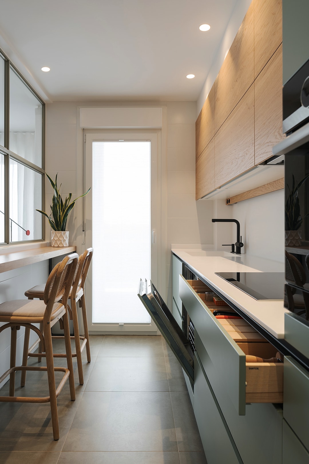 Cozinha com armário verde e piso de madeira
