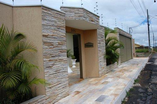 fachada de muro com portão e pedras