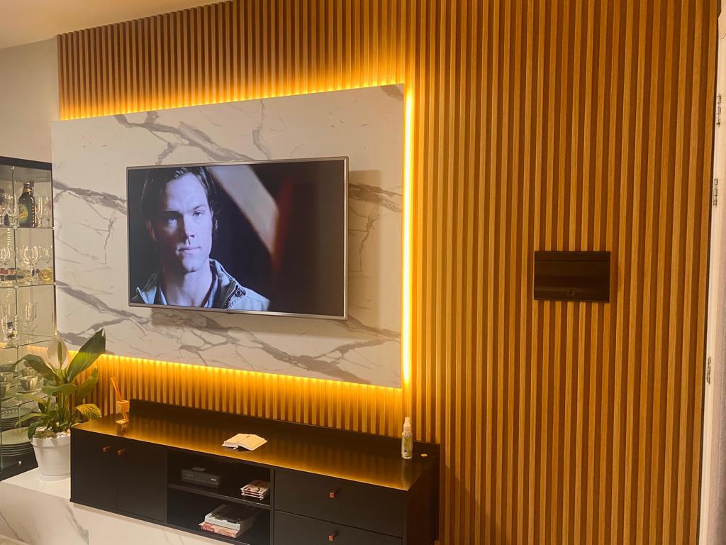 painel de tv ripado com porcelanato e iluminação indireta