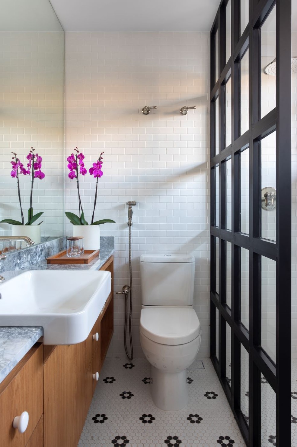 banheiro porcelanato preto e branco com detalhes dourados