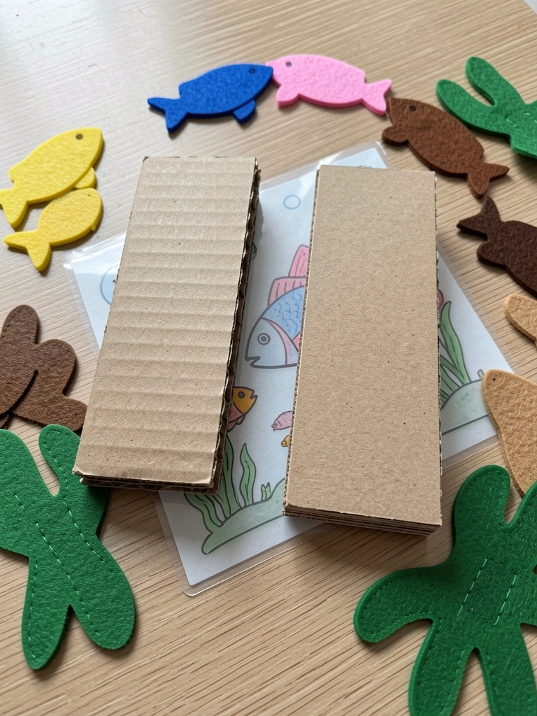 Dois pedaços de papelão de espessuras diferentes, um ao lado do outro, sobre superfície neutra.