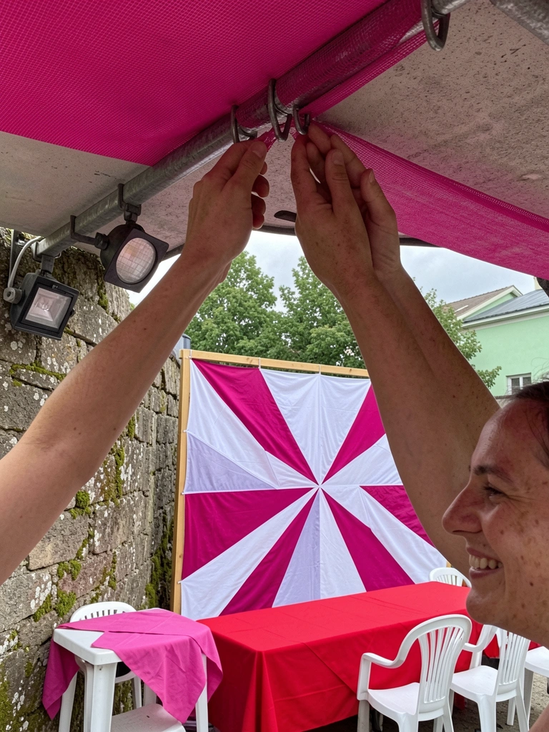 Mãos fixando malha esticada em ganchos no teto