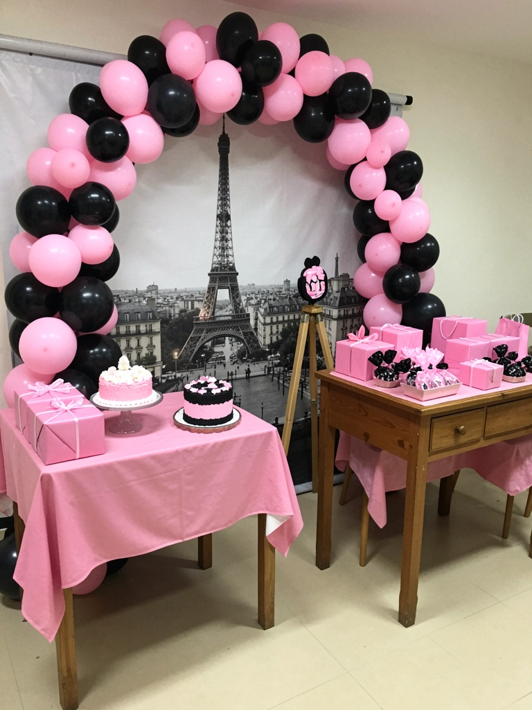 Mesa posta com louça branca, talheres dourados e flores, em estilo parisiense